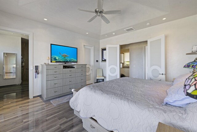 bedroom with ceiling fan, dark wood-type flooring, and a raised ceiling