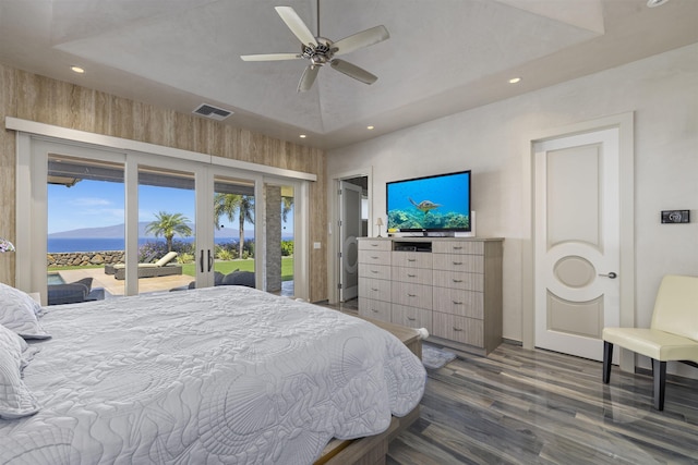 bedroom featuring ceiling fan, a tray ceiling, access to outside, and a mountain view