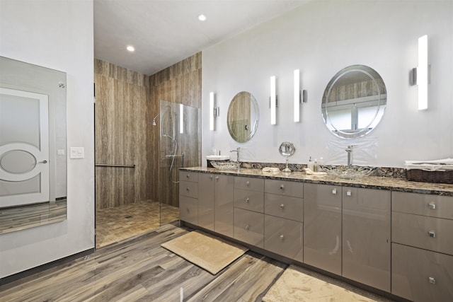 bathroom with vanity, wood-type flooring, and tiled shower