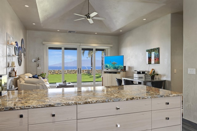 kitchen with light stone counters and ceiling fan