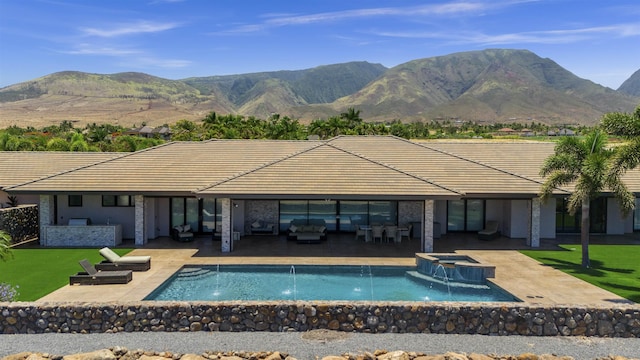 view of swimming pool with pool water feature, a patio area, a mountain view, and an in ground hot tub