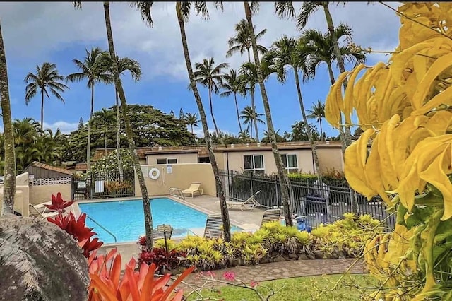 pool with a patio area and fence