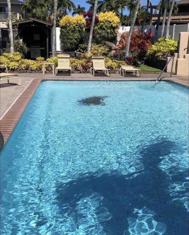 community pool with a patio and fence