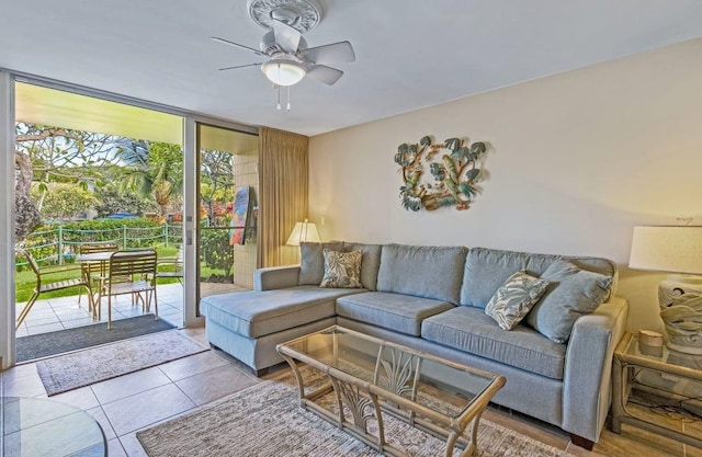 tiled living room featuring a healthy amount of sunlight, expansive windows, and ceiling fan