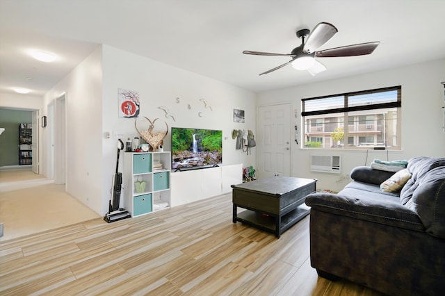 living area featuring a ceiling fan, light wood-style flooring, and a wall unit AC