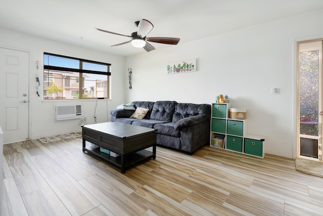 living room with ceiling fan, a wall mounted air conditioner, and light wood finished floors
