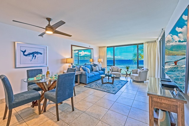 living room with a ceiling fan, floor to ceiling windows, and light tile patterned flooring