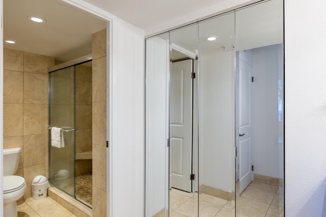 bathroom featuring recessed lighting, a shower stall, toilet, and tile patterned floors