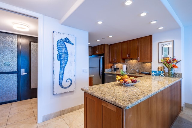 kitchen with stainless steel appliances, tasteful backsplash, light tile patterned flooring, and light stone countertops