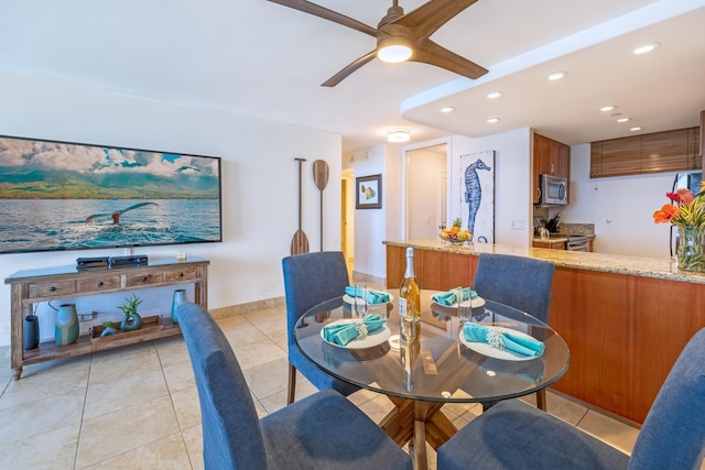 dining room with light tile patterned floors, baseboards, a ceiling fan, and recessed lighting