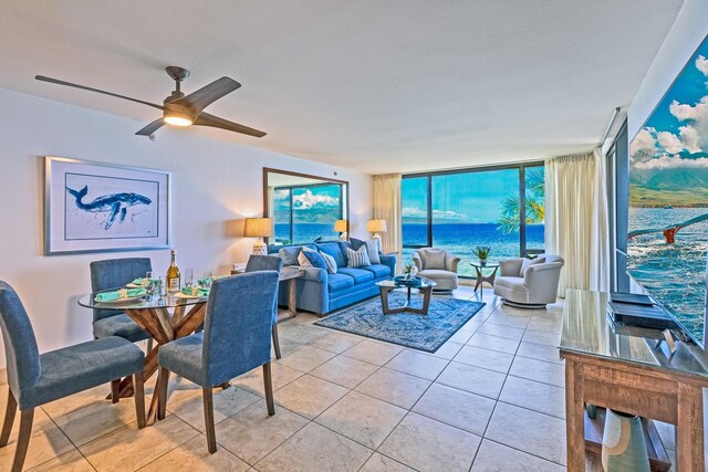 living area with a wall of windows, light tile patterned flooring, and ceiling fan