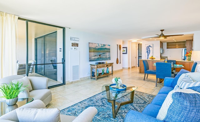 living area with baseboards, visible vents, a ceiling fan, and light tile patterned flooring