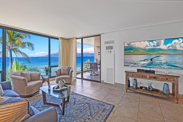 living area featuring expansive windows, visible vents, and tile patterned floors