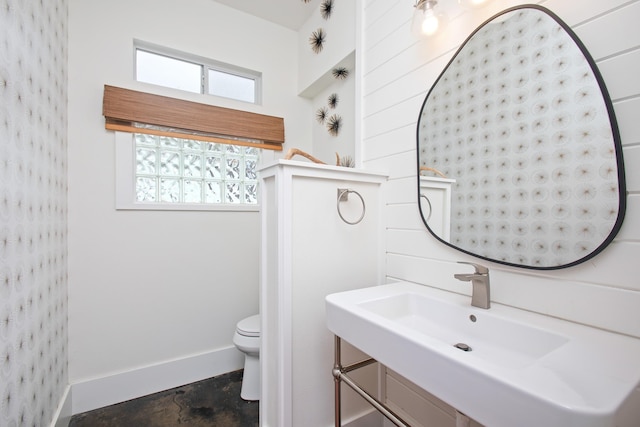 bathroom featuring concrete flooring, toilet, and sink