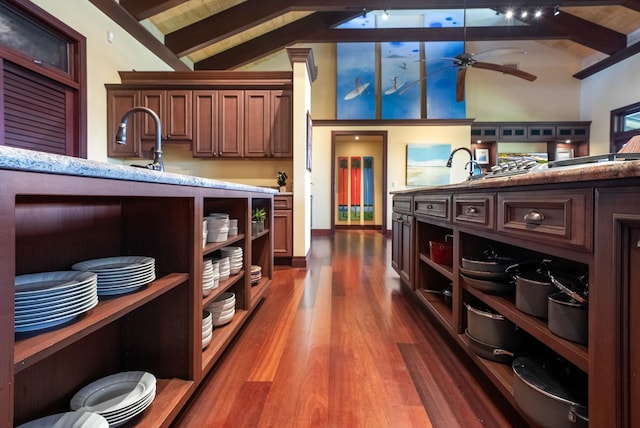 bar with lofted ceiling with beams, ceiling fan, dark wood-type flooring, and a sink