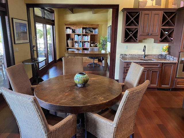 dining space with wet bar and dark wood-style flooring