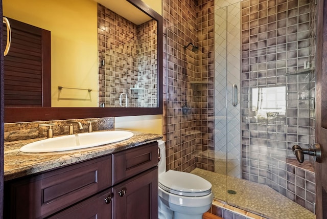 bathroom with toilet, a shower stall, and vanity