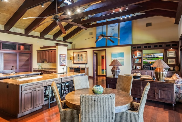 dining space with dark wood-style floors, visible vents, a ceiling fan, high vaulted ceiling, and beamed ceiling