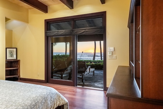 bedroom with access to exterior, dark wood-type flooring, beamed ceiling, and baseboards