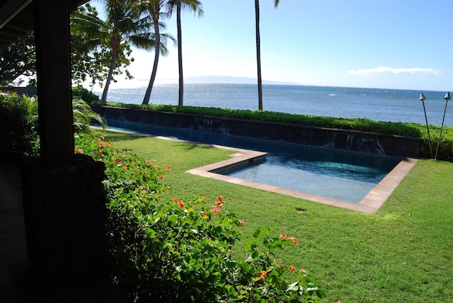 view of swimming pool featuring a yard and a water view