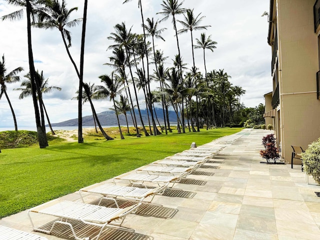 exterior space featuring a patio area, a mountain view, and a lawn