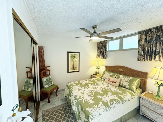 tiled bedroom with a closet, ceiling fan, and a textured ceiling