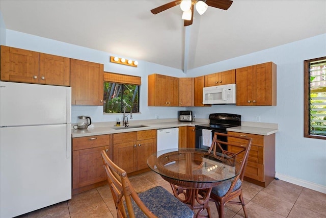 2825 Kauhale St, Kihei, HI 96753 - kitchen with white appliances, light countertops, vaulted ceiling, light tile patterned floors, and brown cabinetry