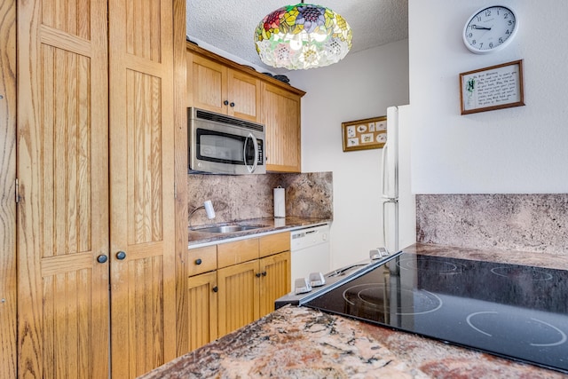 kitchen with decorative light fixtures, white appliances, backsplash, sink, and a textured ceiling