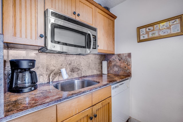 kitchen featuring backsplash, light brown cabinetry, sink, dark stone counters, and dishwasher