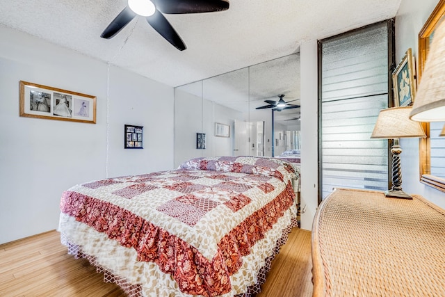 bedroom with wood-type flooring, ceiling fan, and a textured ceiling