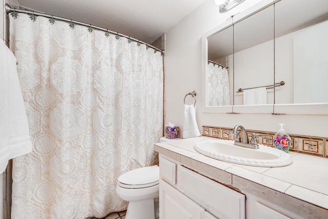 bathroom with tile floors, vanity with extensive cabinet space, and toilet