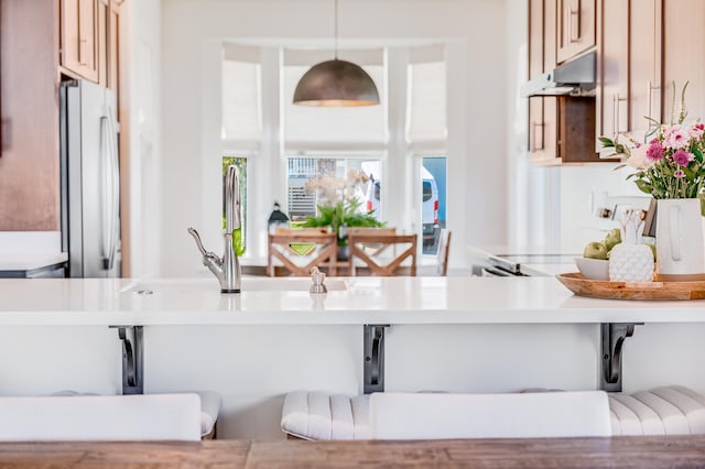 kitchen featuring white refrigerator and hanging light fixtures