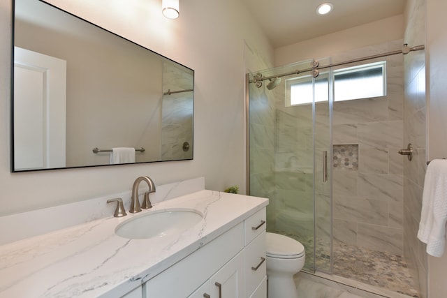 bathroom featuring vanity, toilet, and a shower with door