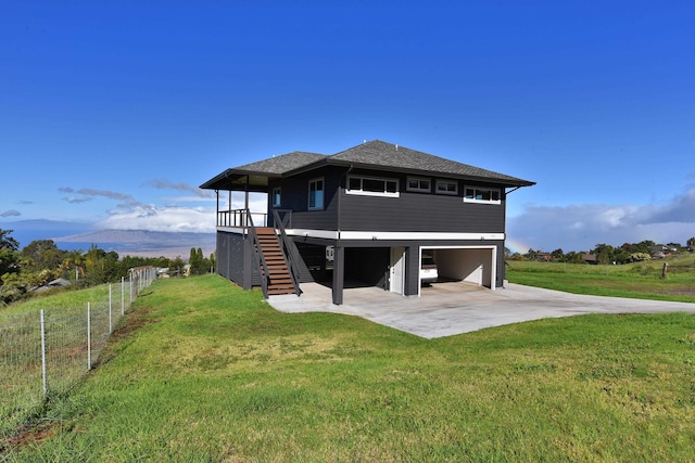 back of house featuring a mountain view, a yard, a rural view, and a garage