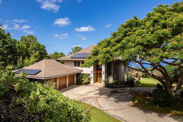 view of front of property with a garage and solar panels