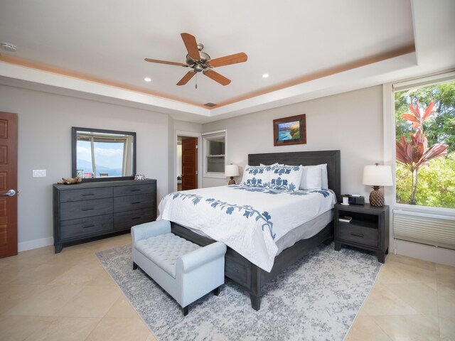 tiled bedroom with ceiling fan and a raised ceiling