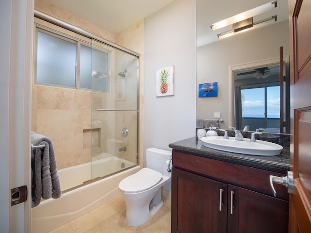 full bathroom featuring combined bath / shower with glass door, tile patterned flooring, toilet, vanity, and ceiling fan