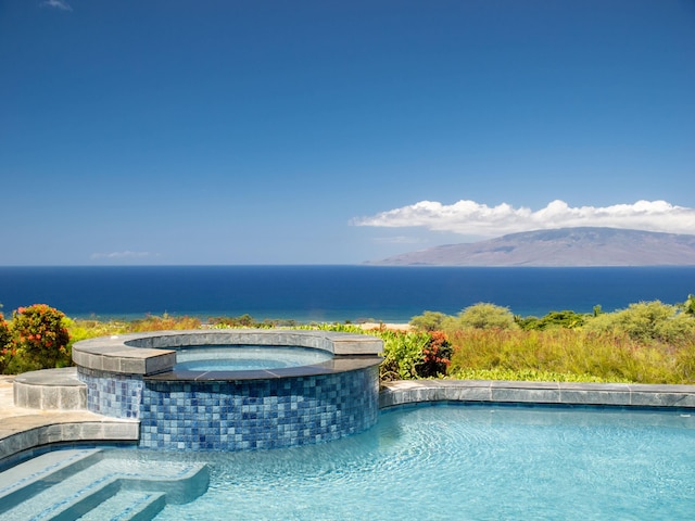 view of pool with an in ground hot tub and pool water feature