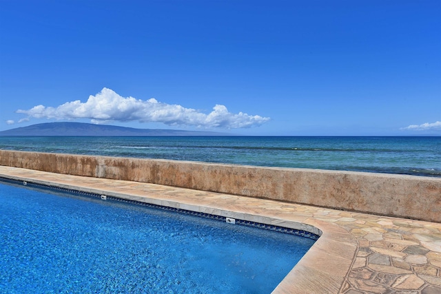 view of swimming pool with a water and mountain view