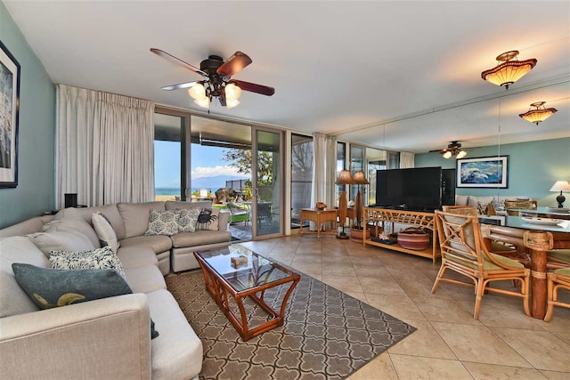 tiled living room with floor to ceiling windows and ceiling fan