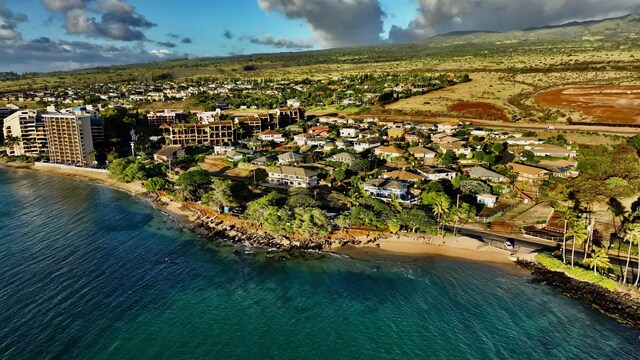 birds eye view of property with a water view and a beach view