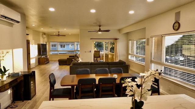 dining room featuring ceiling fan, light hardwood / wood-style floors, and an AC wall unit