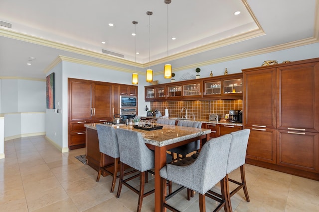 tiled dining space with sink, a raised ceiling, and crown molding