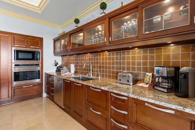 kitchen with sink, ornamental molding, decorative backsplash, light stone countertops, and appliances with stainless steel finishes