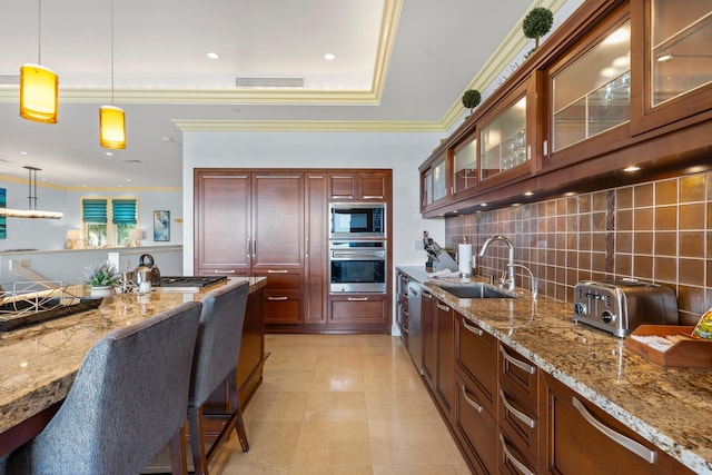 kitchen featuring sink, built in microwave, stainless steel oven, and hanging light fixtures