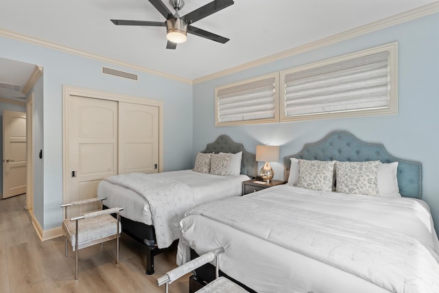 bedroom with a closet, ceiling fan, light hardwood / wood-style floors, and crown molding