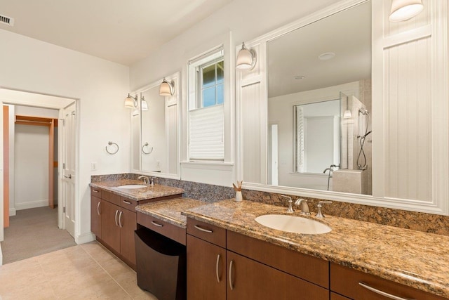 bathroom with walk in shower, vanity, and tile patterned floors