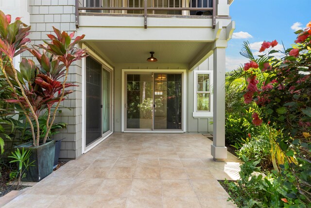 entrance to property featuring a balcony and ceiling fan