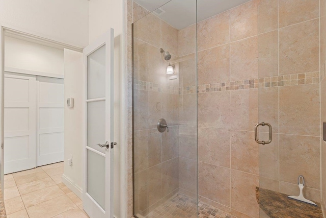 bathroom featuring a shower with shower door and tile patterned floors