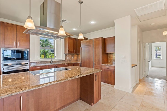 kitchen featuring island range hood, decorative light fixtures, light stone counters, and black appliances